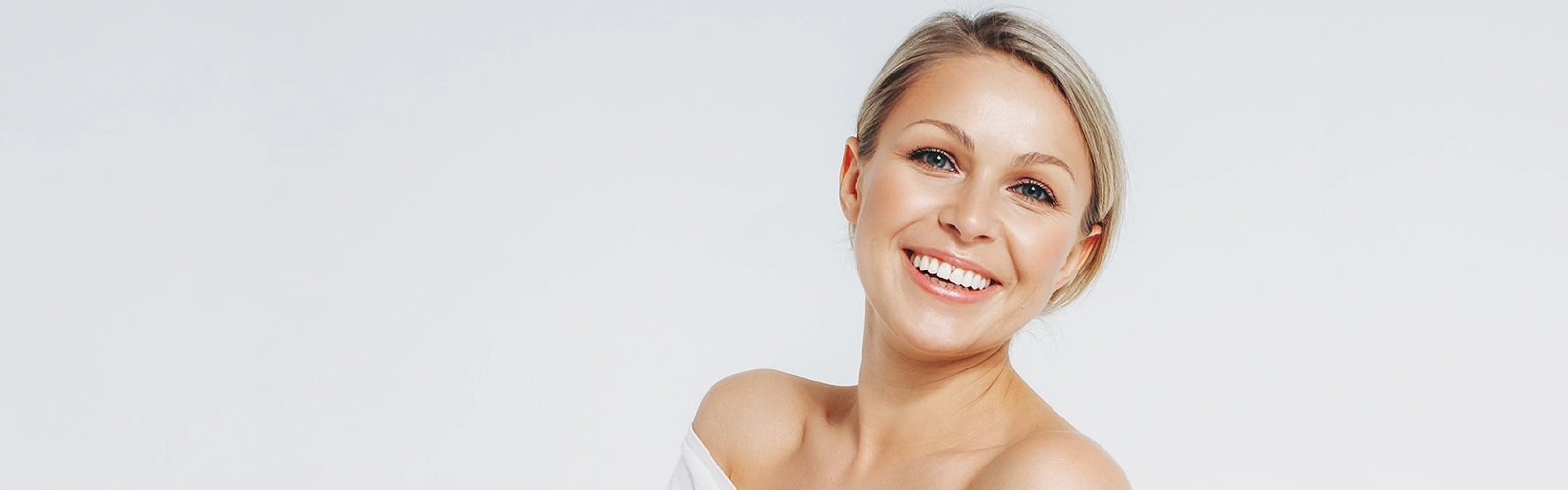 Smiling woman showing natural facial rejuvenation results